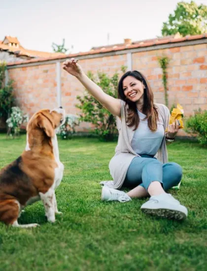 woman playing with a dog outside